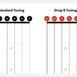 Porównanie strojenia standardowego (EADGBE) i **drop B tuning** (BEADAbDb) na gryfie gitary.