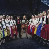 Piękne słowiańskie dziewczyny w tradycyjnych strojach, otaczają parę artystów.