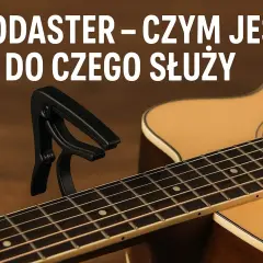 Czarny kapodaster na gryfie gitary akustycznej. Dowiedz się, kapodaster co to jest i do czego służy.