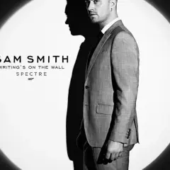 Sam Smith w garniturze, w świetle reflektora, promuje swój utwór "Writing's on the Wall" do filmu o Jamesie Bondzie, Spectre.