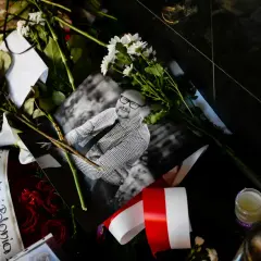 Czarne róże, białe kwiaty i zdjęcie uśmiechniętego mężczyzny. Wstęga z napisem "Exeter Polonia" i polska flaga. Wokół panuje cisza.