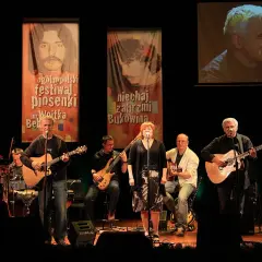 Zespół gra na scenie, w tle banery festiwalu piosenki im. Wojtka Belona. To największe przeboje wolnej grupy Bukowina.
