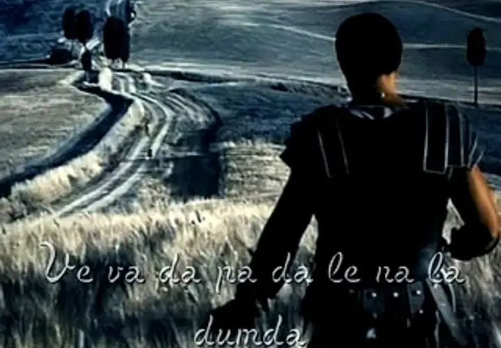 Gladiator w zbroi na tle drogi, jakby słuchał piosenki.