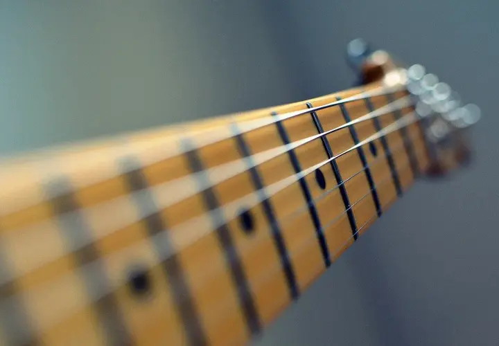 Zbliżenie na gryf gitary elektrycznej. Zastanawiasz się, ile trwa nauka gry na gitarze? To zależy od Ciebie!