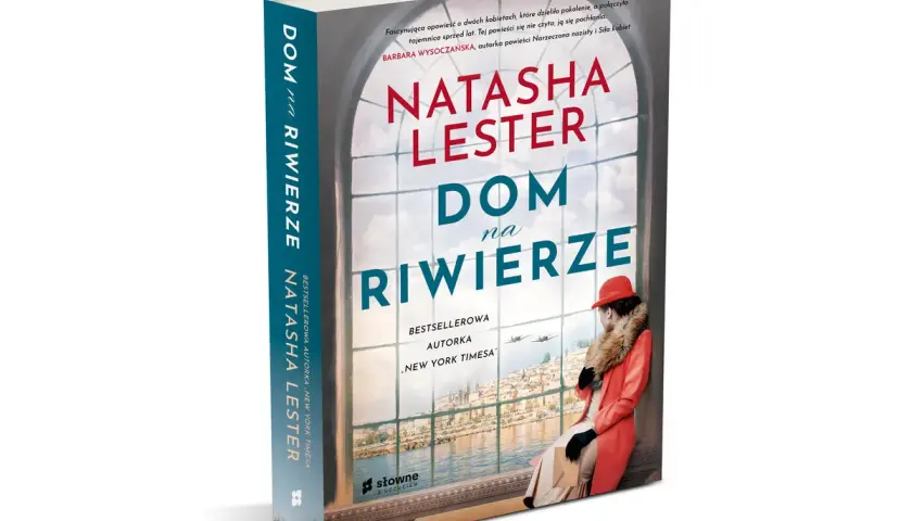 Okładka książki "Dom na Riwierze" Natashy Lester. Widzę dom z widokiem na miasto i morze, a w nim kobietę w czerwonym płaszczu.