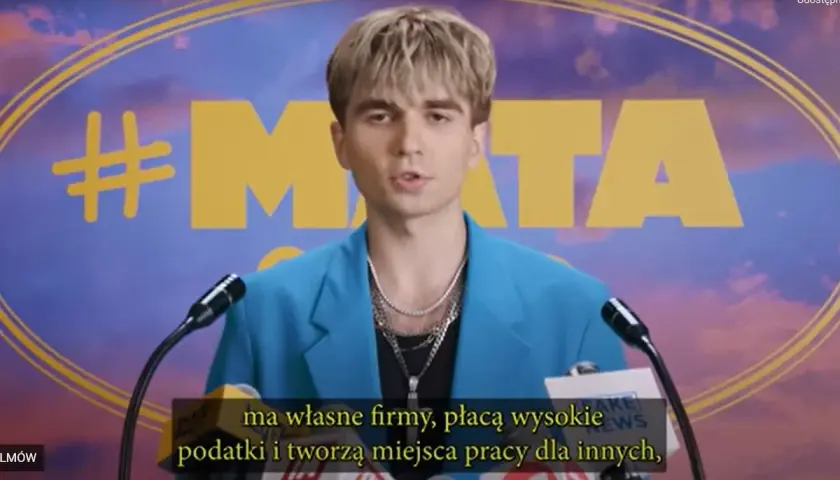 Młody mężczyzna w niebieskiej marynarce, z hasłem #MATA na tle. Mówi o firmach, podatkach i tworzeniu miejsc pracy.