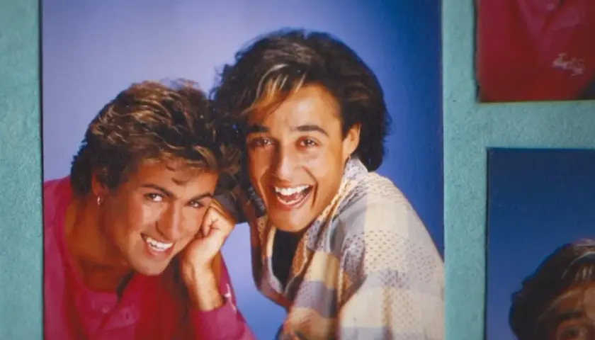George Michael i Andrew Ridgeley z Wham! uśmiechają się radośnie. Ich klasyczne george michael utwory wciąż brzmią w naszych sercach.
