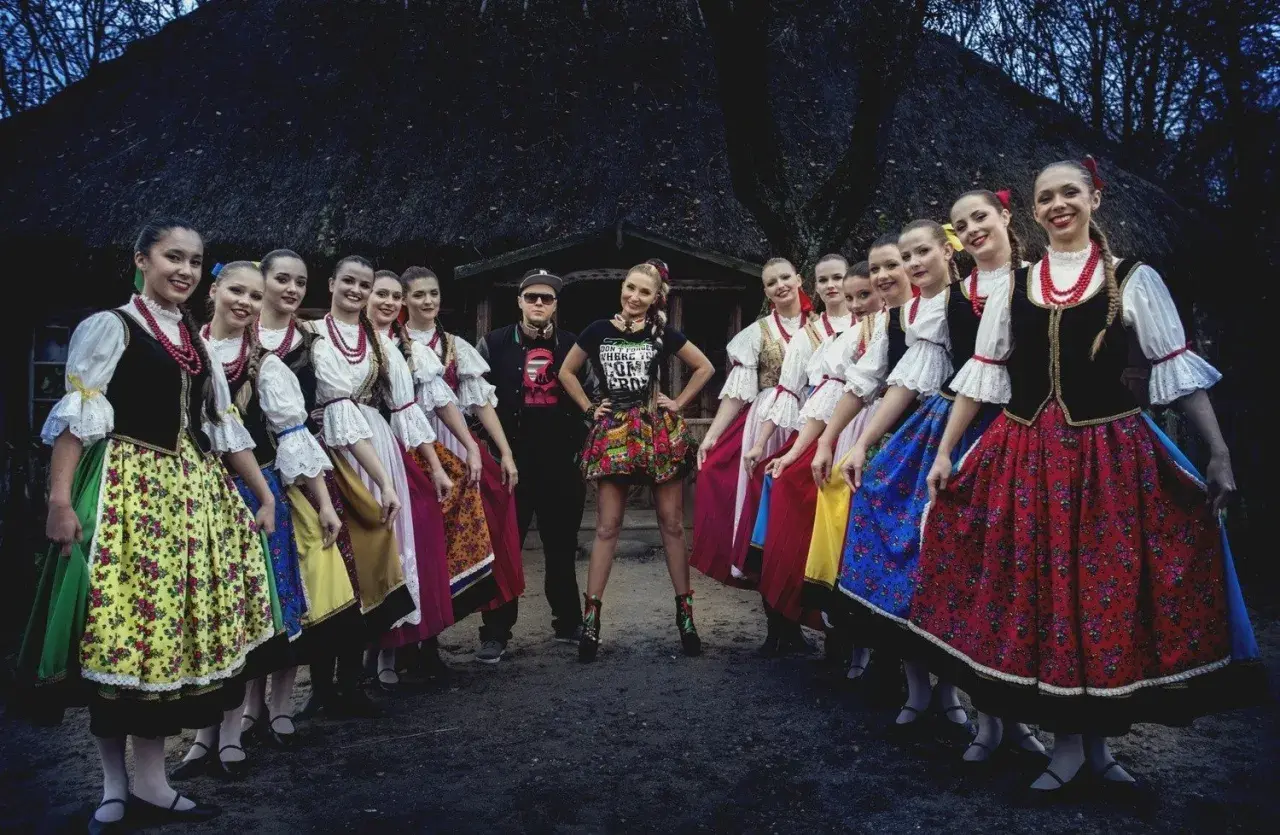 Piękne słowiańskie dziewczyny w tradycyjnych strojach, otaczają parę artystów.