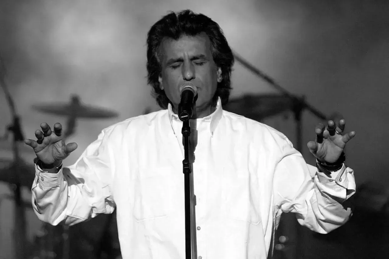 Toto Cutugno śpiewa "L'Italiano", z zamkniętymi oczami i uniesionymi rękami.