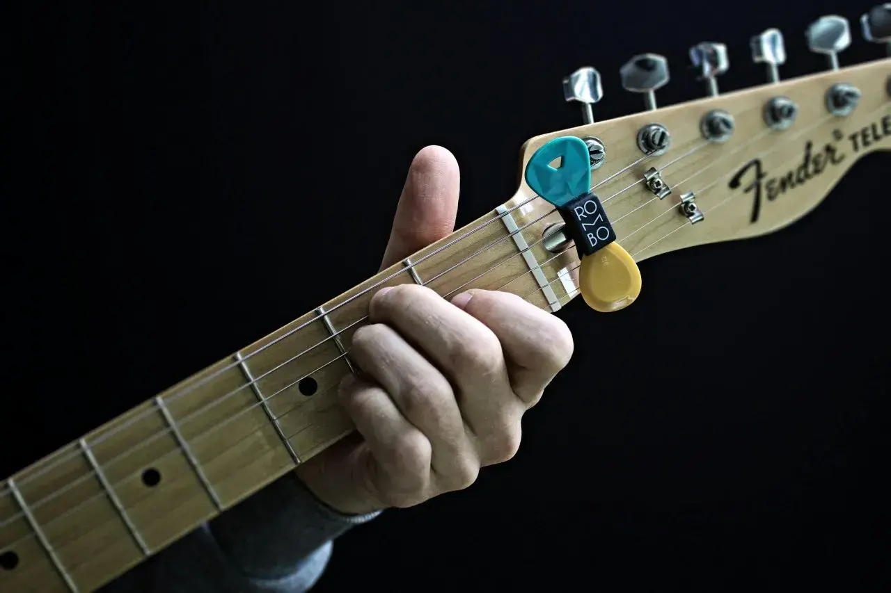 Dłoń grająca akord a dur na gitarze Fender Telecaster. Kostka z uchwytem Rombo.