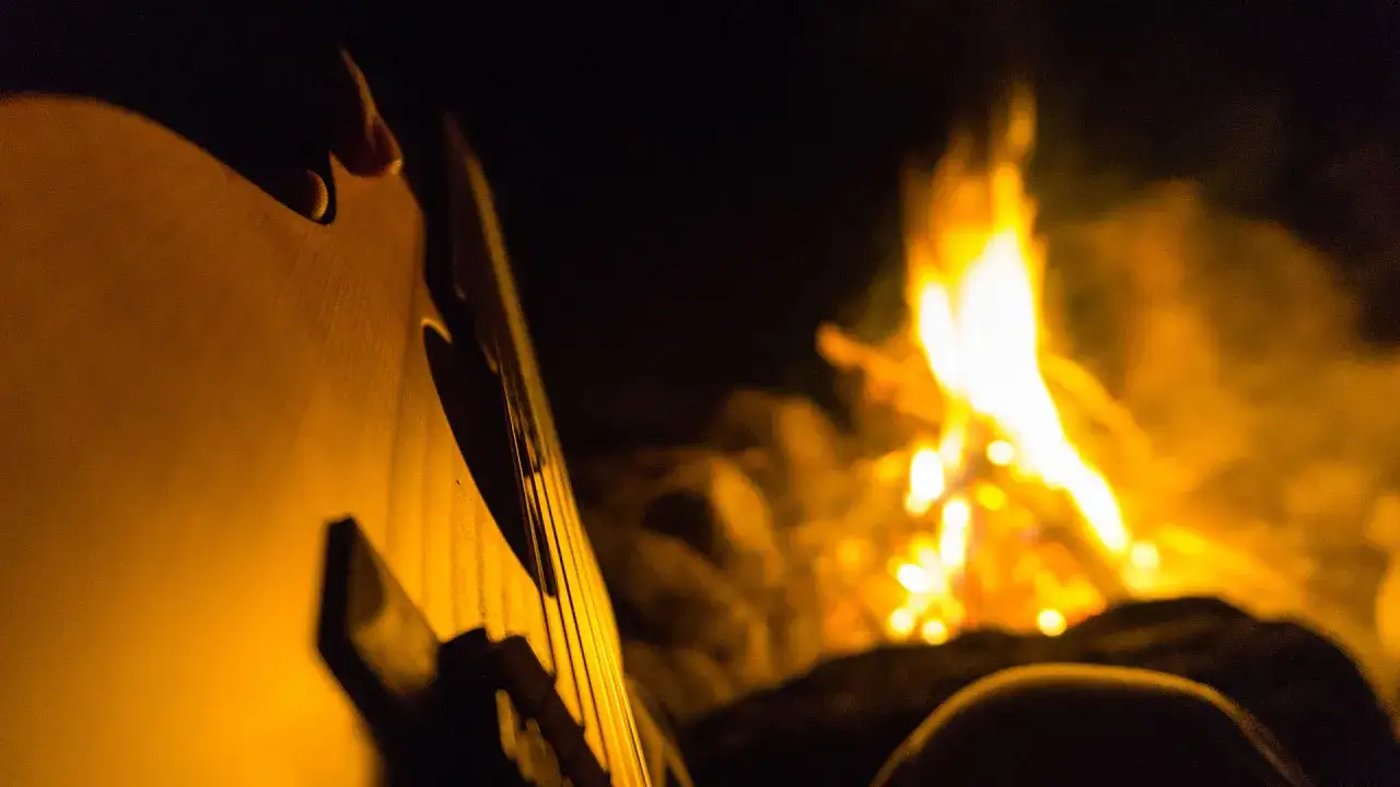 Przy ognisku, gitara i najpopularniejsze piosenki turystyczne tworzą magiczną atmosferę.