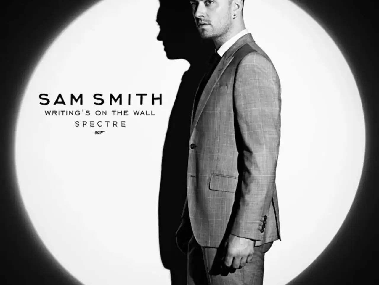Sam Smith w garniturze, w świetle reflektora, promuje swój utwór 